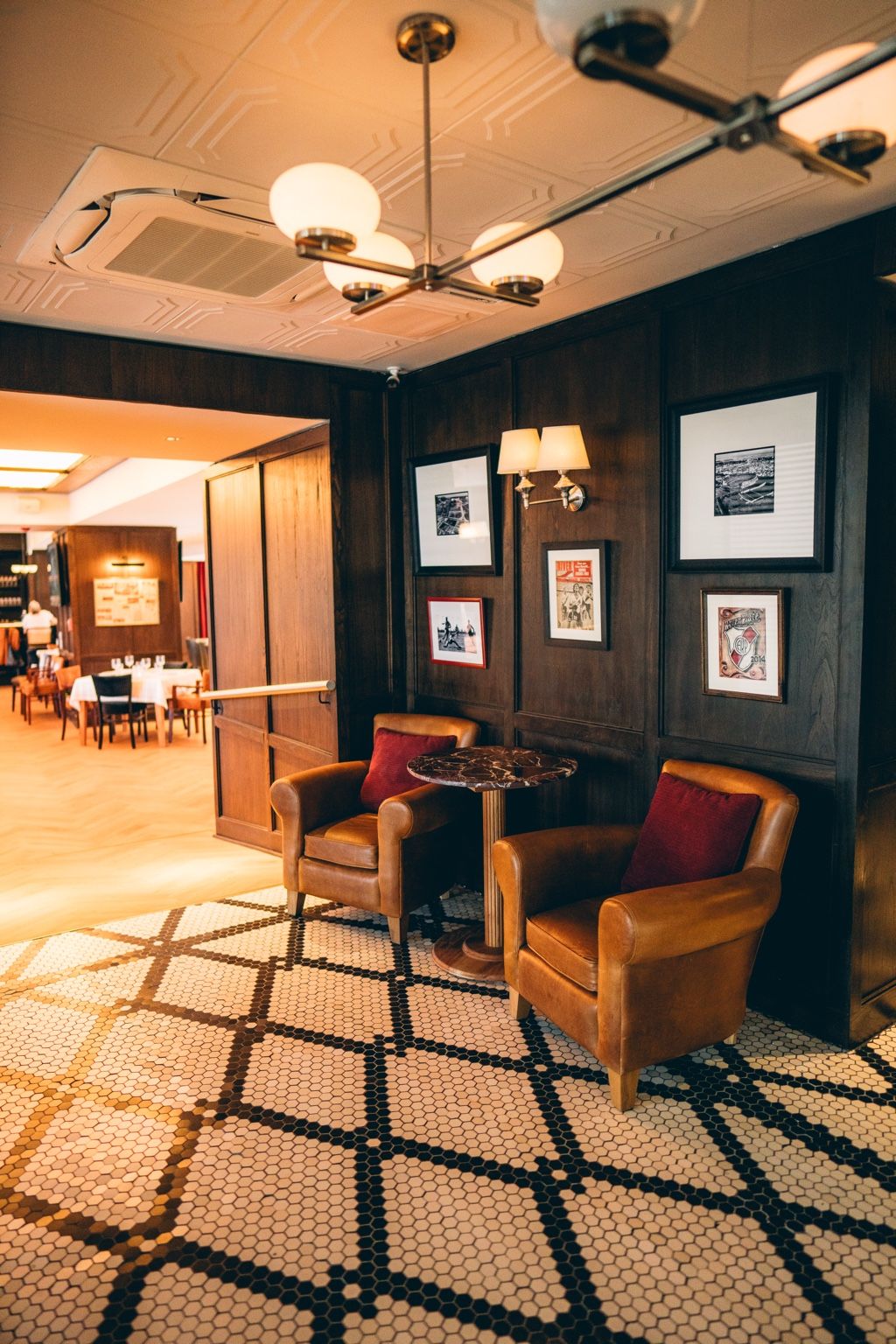 Lobby de Bodegón 1901 con sillones de cuero y pisos de mosaico