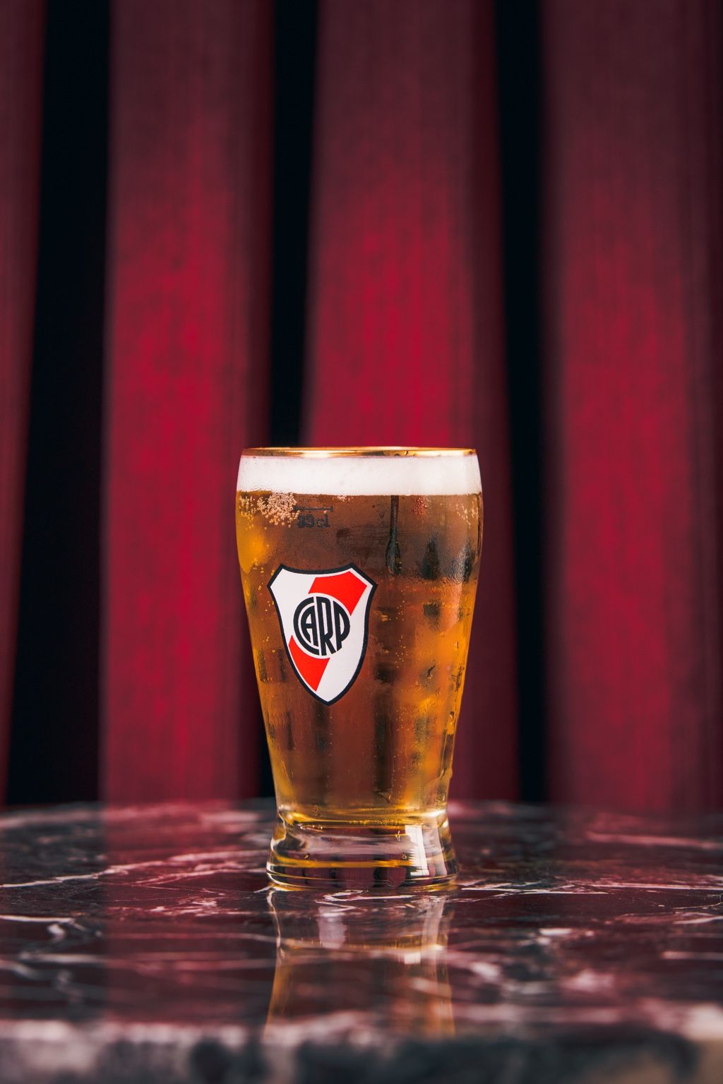 Cerveza tirada en vaso con escudo de River Plate