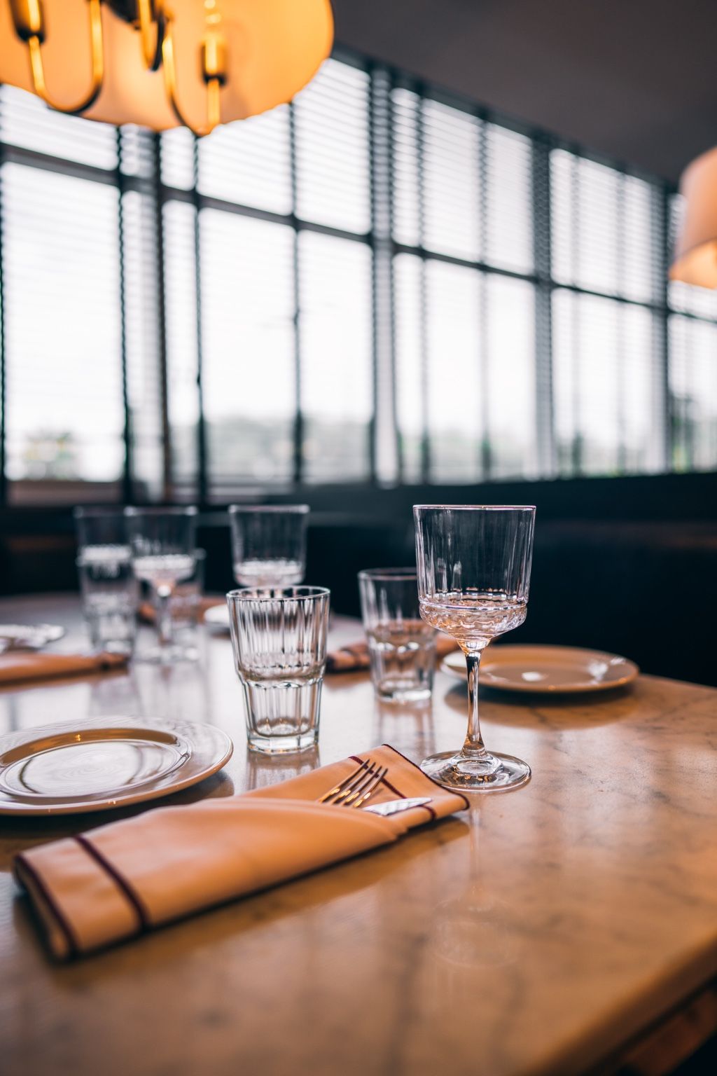 Detalle de mesa con cristalería y servilleta bordó